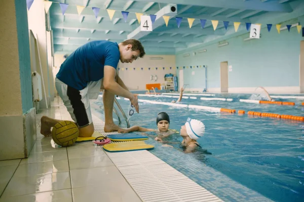 two-schoolgirl-water-polo-players-listening-teacher-poolside-have-fun-play-splash-blue-swimming-pool